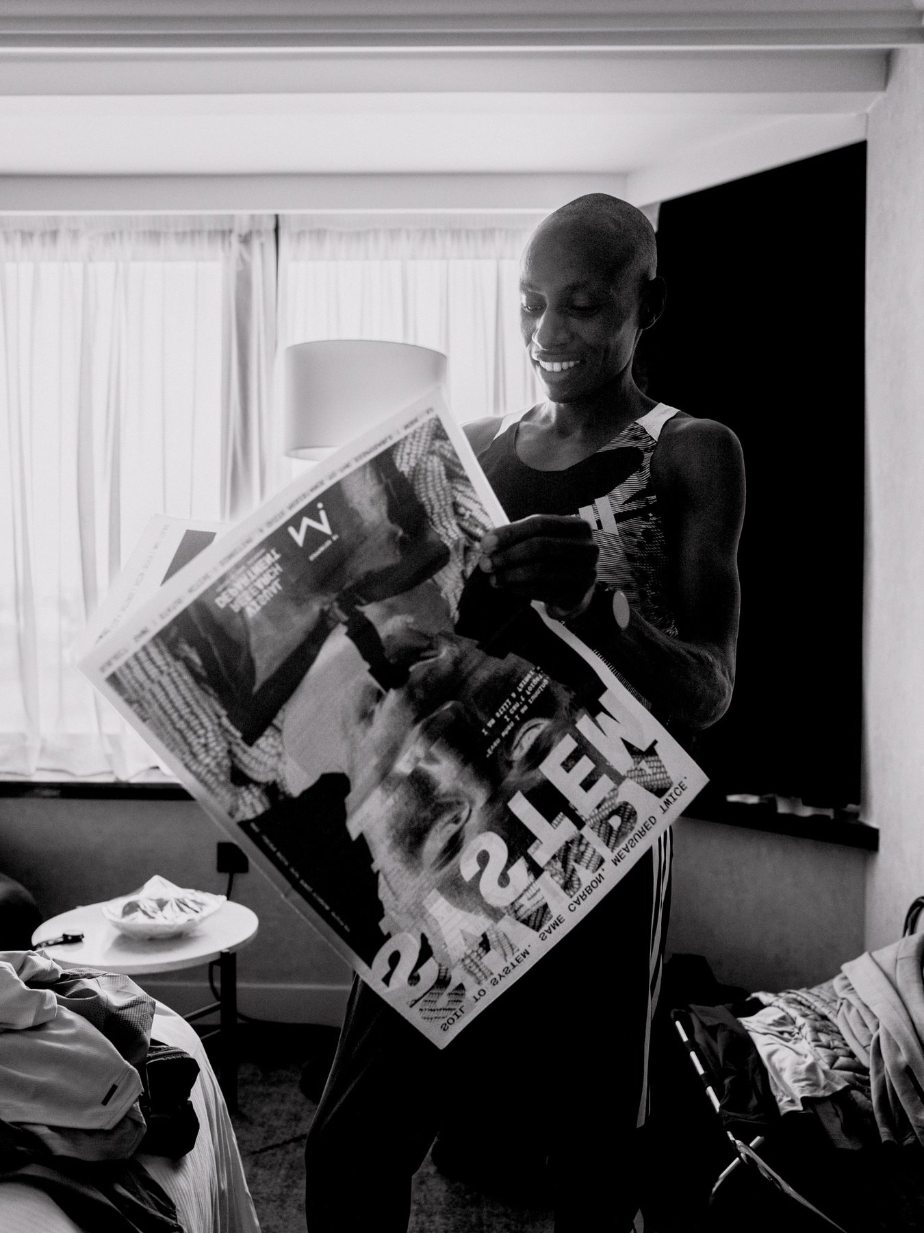 Sabastian Sawe smiling while reading the Shamba System newspaper.